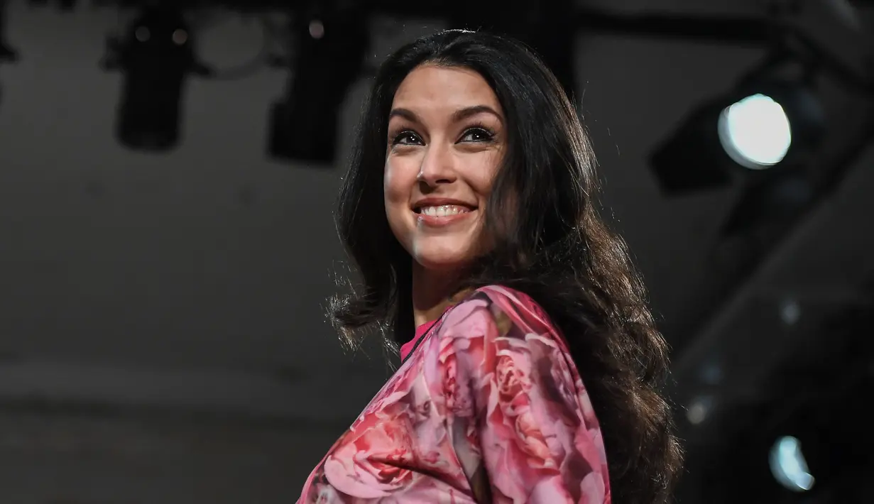  Model Rebecca Mir tersenyum saat mengenakan busana ciptaan Riani di Berlin Fashion Week 2017 di Berlin Jerman (17/1). (AFP Photo/dpa/Britta Pedersen/Jerman OUT)
