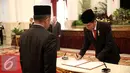  Presiden Jokowi menandatangani saat melantik Kepala Badan Nasional Penanggulangan Terorisme (BNPT) dan Kepala Badan Keamanan Laut (Bakamla) di Istana Negara, Jakarta, Rabu (16/3).  (Liputan6.com/Faizal Fanani)