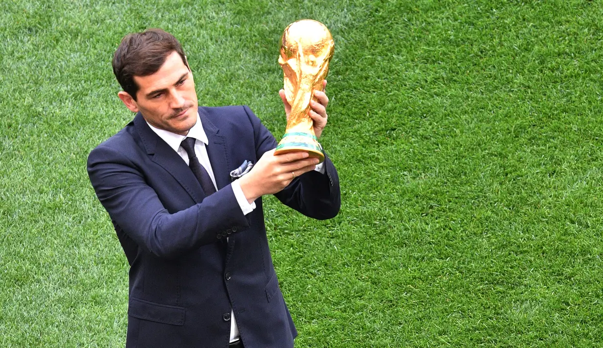 Mantan kiper timnas Spanyol, Iker Casillas memamerkan trofi Piala Dunia 2018 sebelum laga pembuka di stadion Luzhniki, Moskow, Kamis (14/6). Trofi Piala Dunia itu memiliki tinggi 36 centimeter dan berat 6,175 kg dengan 18 karat emas. (AFP/Mladen ANTONOV)