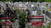 Warga keturunan Tionghoa membersihkan makam keluarga saat Festival Cheng Beng di Pemakaman Tionghoa di Japakeh, Banda Aceh, Aceh, Minggu (26/3/2023). (CHAIDEER MAHYUDDIN/AFP)