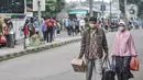 Pemudik membawa barang mereka seusai turun dari bus antarkota antarprovinsi (AKAP) di Terminal Kampung Rambutan, Jakarta, Minggu (23/5/2021). Hingga sore ini pemudik dari kota di Jawa Barat, Tengah, Timur, dan Sumatera terus berdatangan di Terminal Kampung Rambutan. (merdeka.com/Iqbal S Nugroho)