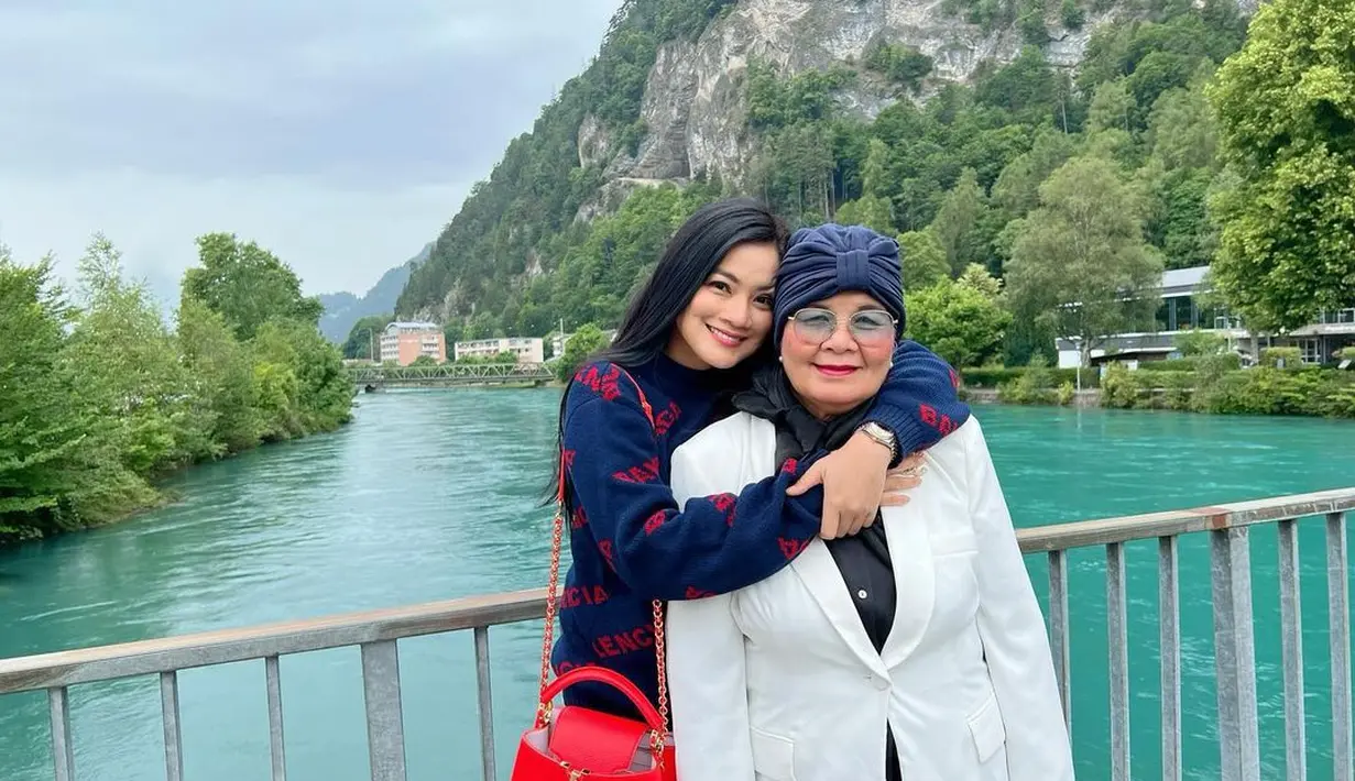 Titi Kamal bersama sang mama saat berpose di pinggir sungai di Swiss. Sebelumnya Titi mengajak mamanya untuk jalan-jalan menikmati keindahan di negara-negara Eropa salah satunya Prancis. (instagram/titi_kamall)