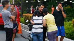 Dua wanita bereaksi setelah saudaranya selamat dari penembakan brutal di Resorts World Manila, Jumat (2/6). Serangan pria bersenjata dilaporkan telah melukai puluhan tamu hotel dan kasino yang berlarian setelah penembakan muncul (AP Photo/Bullit Marquez)