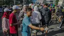 Seorang pria membagikan stiker ajakan menggunakan hak pilih pada kegiatan sosialisasi pemilu di kawasan Bundaran HI, Jakarta, Minggu (14/4). Sejumlah Komunitas mensosialisasikan kegiatan pemilu damai tanpa hoaks dan golput menjelang pelaksanaan pemilu 17 April 2019 mendatang. (Liputan6.com/Faizal Fa
