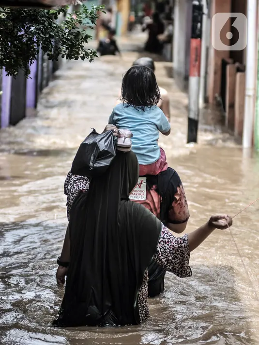 Warga berpegangan pada tali saat menyusuri banjir yang merendam permukiman di Kebon Pala, Jakarta, Senin (8/2/2021). Hujan deras yang mengguyur Ibu Kota dan wilayah Bogor menyebabkan permukiman di Kebon Pala terendam banjir sejak Minggu (7/2/2021) sore. (merdeka.com/Iqbal S. Nugroho)