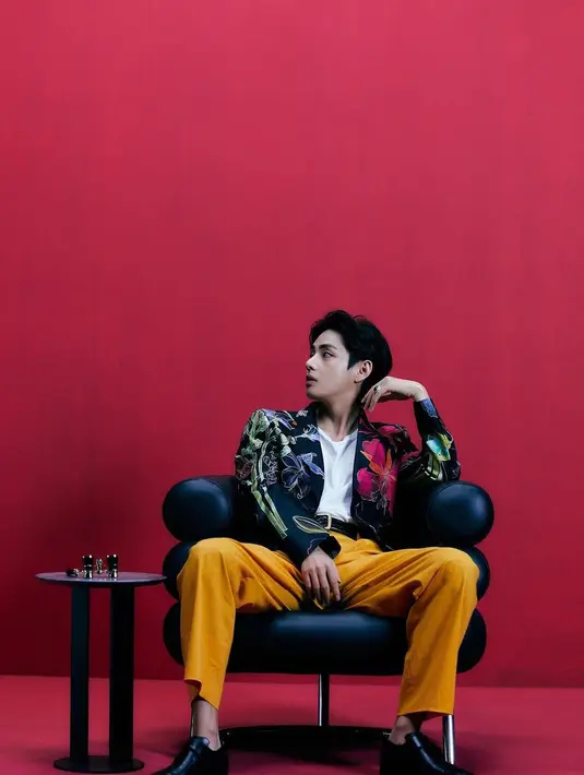 Taehyung dalam outfit yang lebih colorful dan tetap memesona. Mengenakan kaus putih polos yang ditumpuknya dengan blazer hitam bermotif floral berwarna-warni, Taehyung memadukannya dengan celana panjang berwarna mustard yang kontras, namun tetap terlihat serasi. Foto: Instagram.