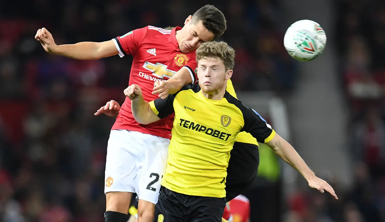 Duel pemain Manchester United, Ander Herrera (kiri) dan pemain Burton Albion, Matt Palmer pada laga Piala Liga Inggris di Old Trafford, Manchester (20/9/2017). MU menang 4-1. (AFP/Paul Ellis)