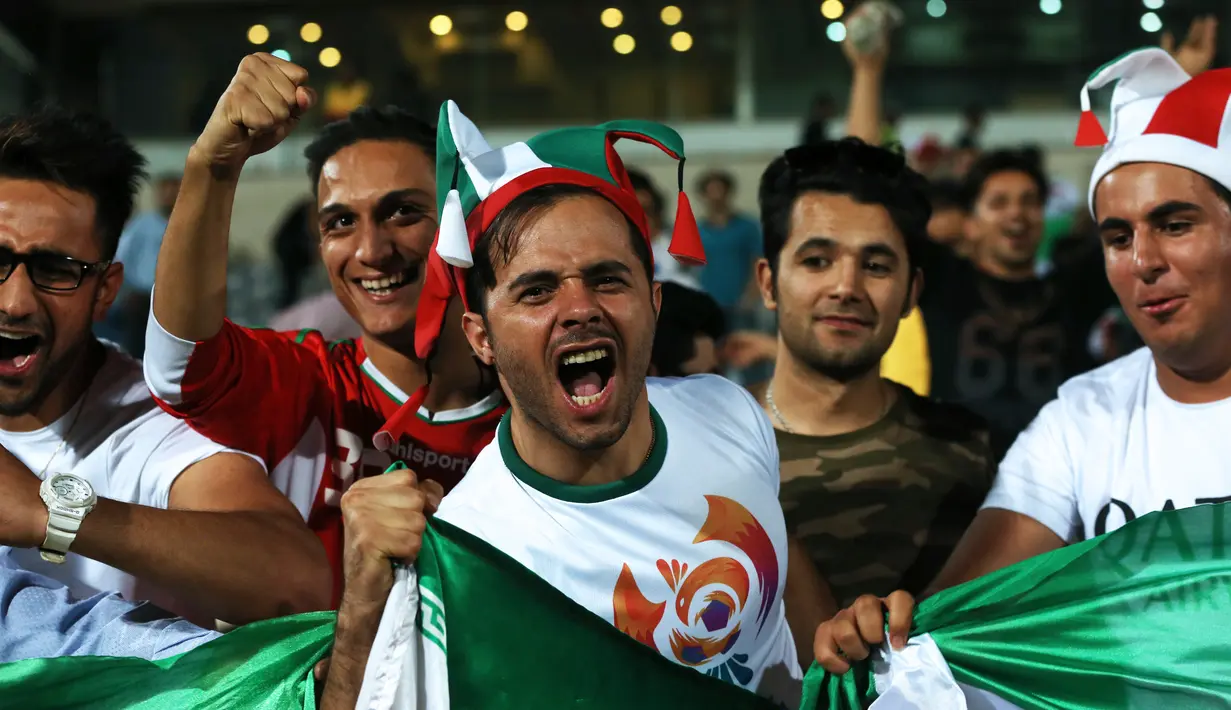 Sejumlah suporter merayakan kemenangan timnas Iran atas Uzbekistan dalam kualifikasi Grup A zona Asia di Stadion Azadi, Senin (12/6). Iran menjadi negara ketiga yang memastikan diri tampil ke putaran final Piala Dunia 2018. (AP Photo/Vahid Salemi)