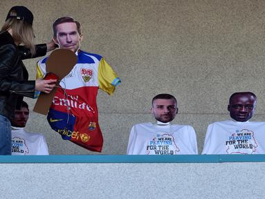 Seorang peremuan memasang maneken untuk menggantikan penonton saat pertandingan Liga Belarusia antara FC Dynamo-Brest dan FC Isloch di Brest, Minggu (12/4/2020). Kompetisi teratas Liga Belarusia ini menjadi satu-satunya liga di Eropa yang masih berjalan di tengah pandemi corona. (Sergei GAPON/AFP)