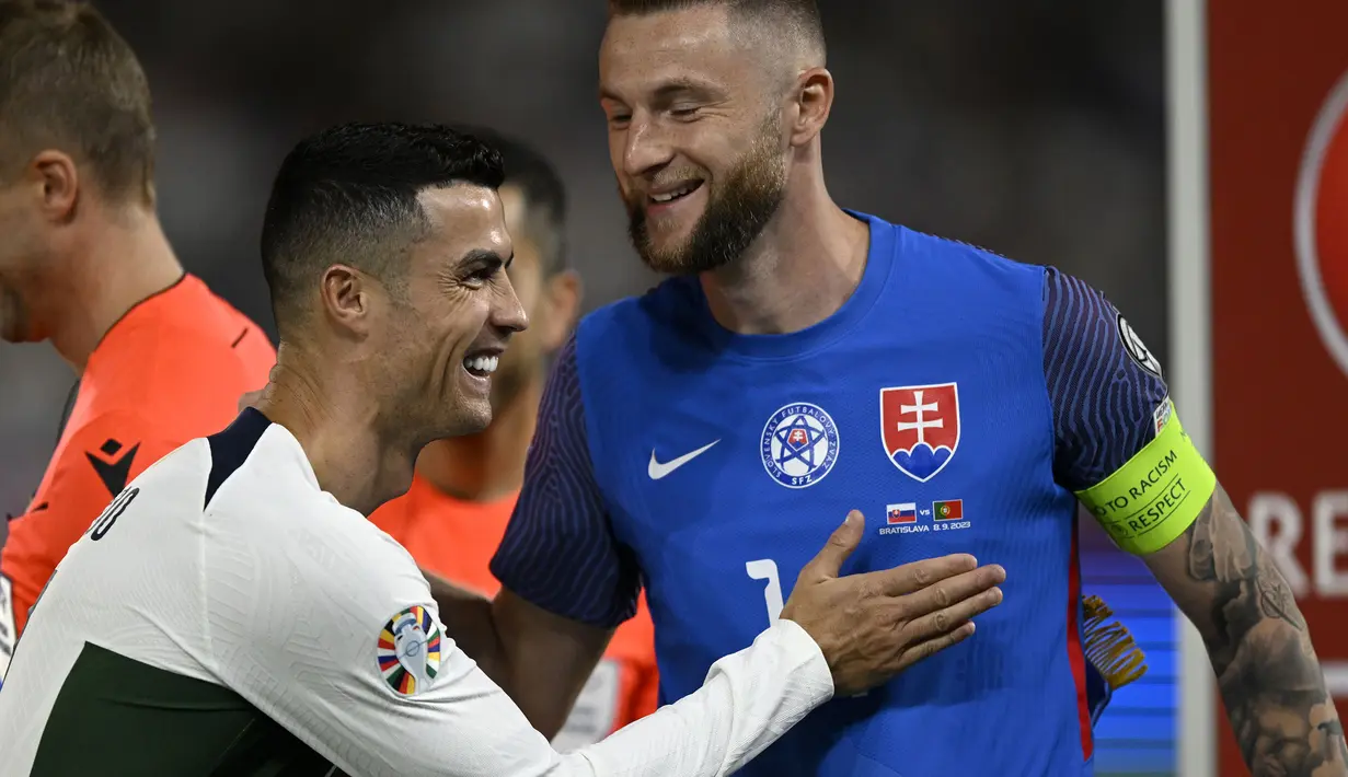 Kapten Timnas Portugal, Cristiano Ronaldo dan kapten Timnas Slovakia, Milan Skriniar saling melempar senyum sebelum dimulainya laga Grup J kualifikasi Euro 2024 di National Football Stadium, Bratislava, Slovakia, Sabtu (9/9/2023) dini hari WIB. (AP Photo/Radovan Stoklasa)