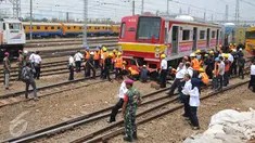 Sejumlah Petugas saat mengevakuasi gerbong kereta yang anjlok di jalur kereta api manggarai, Jakarta, Selasa (27/10/2015). Para Penumpang berhamburan turun  menyelamatkan diri. (Liputan6.com/Gempur M Surya)
