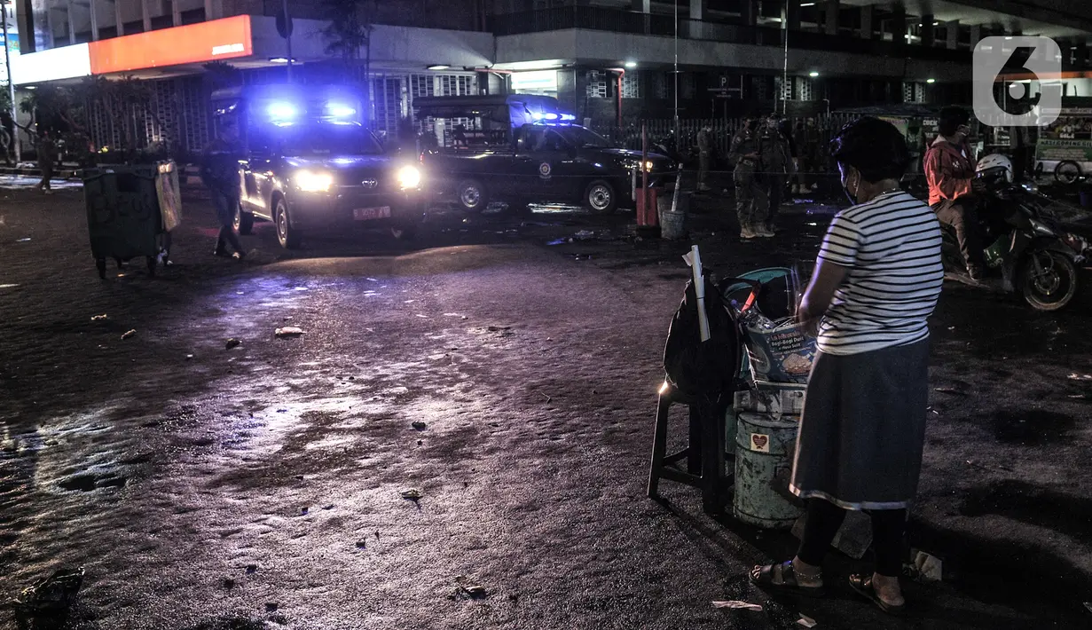 Pedagang merapikan dagangannya saat petugas Satpol PP melakukan penertiban di kawasan Kota Tua, Jakarta, Kamis (31/12/2020). Penertiban dilakukan guna mencegah kerumunan seiring larangan bagi warga merayakan malam Tahun Baru di Kota Tua di tengah pandemi COVID-19. (merdeka.com/Iqbal S. Nugroho)