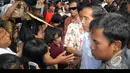 Jokowi menyempatkan diri untuk membagian uang sendiri kepada warga yang antre di tengah teriknya matahari dan debu di pinggiran waduk, Jakarta, Kamis (24/7/2014) (Liputan6.com/Herman Zakharia)
