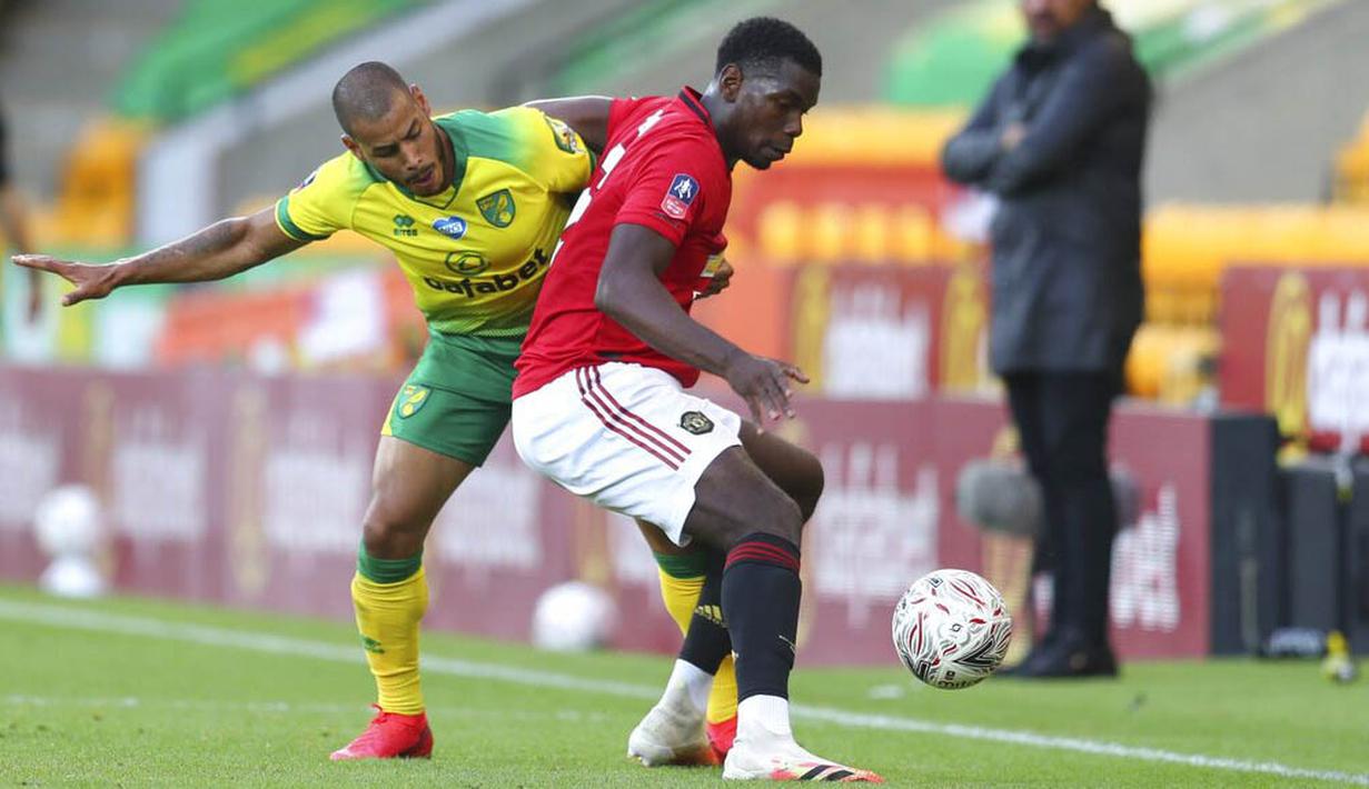 Gelandang Manchester United, Paul Pogba, berebut bola dengan pemain Norwich City, Onel Hernandez, pada laga Piala FA di Carrow Road, Norwich, Sabtu (27/6/2020). Manchester United menang 2-1 atas Norwich City. (AP/Catherine Ivill)