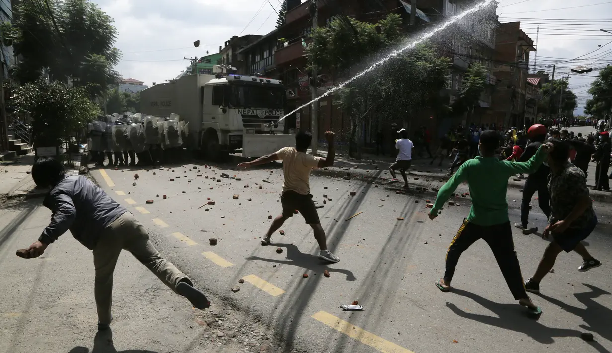 Warga melempari batu ketika kegiatan menarik kereta Dewa Rato Machhindranath dalam sebuah festival keagamaan dihentikan aparat kepolisian di Lalitpur, Nepal (3/9/2020). Aparat kepolisian berupaya membubarkan warga untuk mengendalikan penyebaran Covid-19. (AP Photo/Niranjan Shrestha)