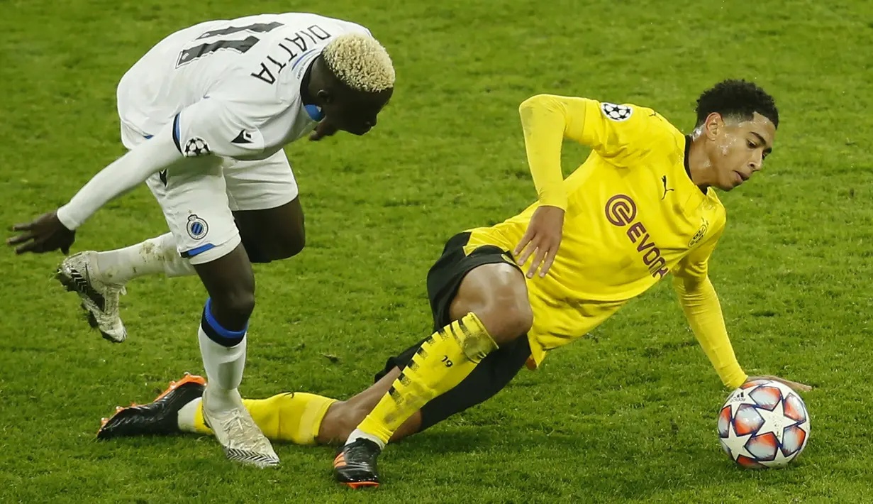 Gelandang Borussia Dortmund, Jude Bellingham, berebut bola dengan gelandang Club Brugge, Krepin Diatta, pada laga lanjutan Liga Champions di Signal Iduna Park, Rabu (25/11/2020) dini hari WIB. Borussia Dortmund menang 3-0 atas Club Brugge. (AFP/Leon Kuegeler/pool)