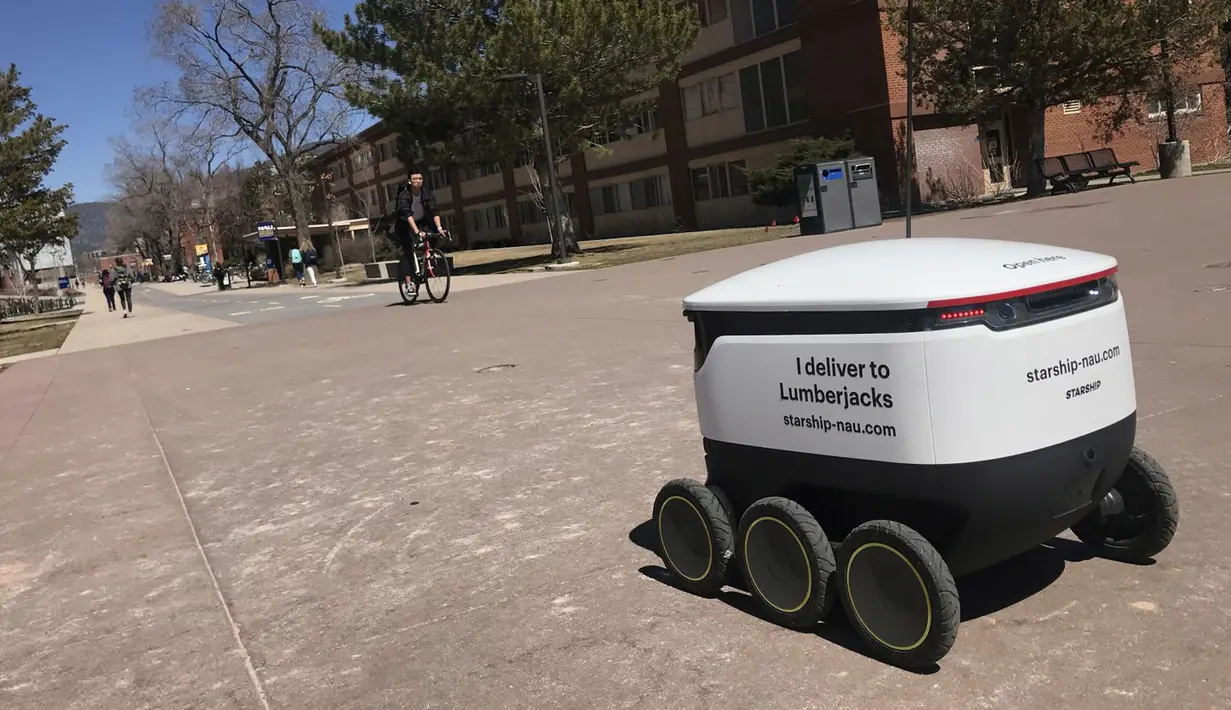Sebuah robot pengantar makanan melintasi kampus Northern Arizona University di Flagstaff, Arizona, Amerika Serikat, Selasa (26/3). Ada lusinan robot pengantar makanan di kampus ini. (Ben Shanahan/Arizona Daily Sun via AP)