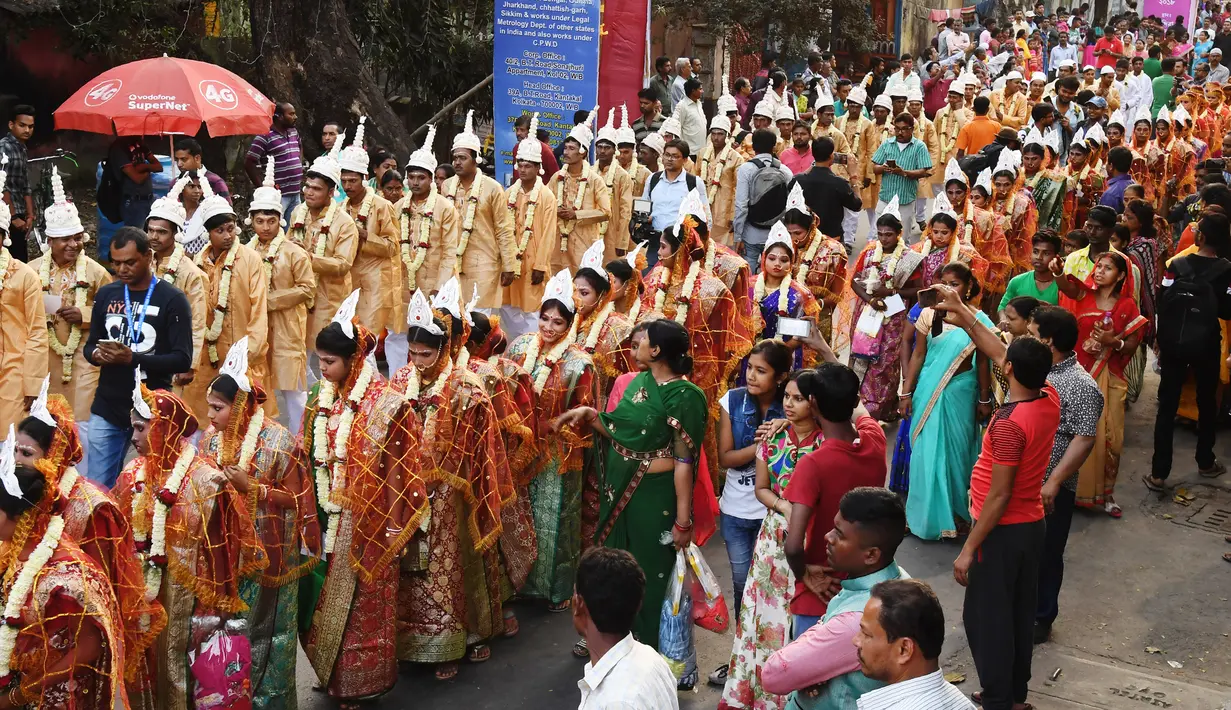Sejumlah pasangan calon pengantin berbaris saat mengikuti upacara pernikahan massal di Kolkata, India (14/2). (AFP Photo/Dibyangshu Sarkar)