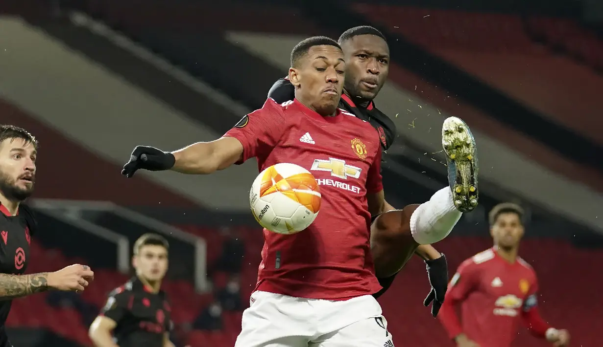 Striker Manchester United, Anthony Martial (depan) berebut bola dengan bek Real Sociedad, Modibo Sagnan dalam laga leg kedua babak 32 Besar Liga Europa 2020/21 di Old Trafford Stadium, Kamis (25/2/2021). Manchester United bermain imbang 0-0 dengan Real Sociedad. (AP/Dave Thompson)