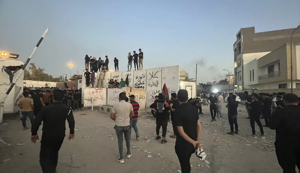 Para pengunjuk rasa yang marah dengan rencana pembakaran salinan Al Quran menyerbu Kedutaan Besar Swedia di Baghdad Kamis pagi, masuk ke dalam kompleks dan menyalakan api kecil. (AP Photo/Ali Jabar)