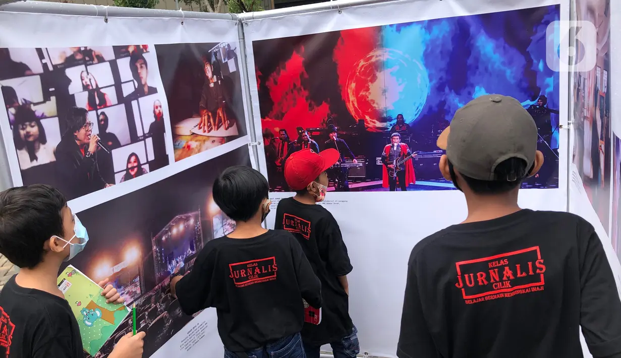 Komunitas “Kelas Jurnalis Cilik” dipandu pewarta foto mengikuti kegiatan tur pameran fotografi bertema 'Ragam Cerita Ibu Kota Sebelum dan Saat Pandemi COVID-19' di Thamrin 10, Jakarta, Minggu (6/12/2020). Pameran tersebut berlangsung hingga 13 Desember 2020. (Liputan6.com/Immanuel Antonius)