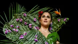 Model mengenakan busana rancangan desainer Kolombia, Estefania Russi selama BioFashion Show di Cali  pada 17 November 2018. Busana-busana yang ditampilkan di ajang ini seluruhnya terbuat dari tanaman hidup, bunga dan unsur organik lain. (Luis ROBAYO/AFP)