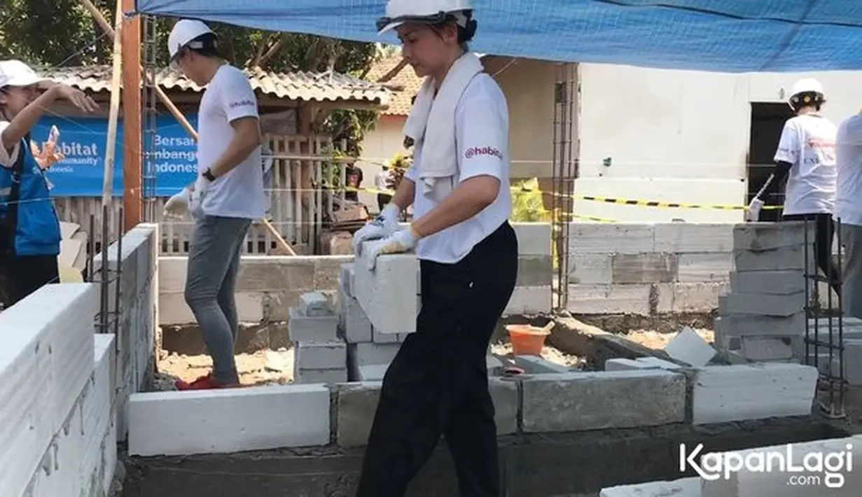 Bagi perempuan empat anak ini, menjadi tukang bangunan merupakan pengalaman pertamanya. Seperti tukang bangunan profesional, Joanna tampak antusias saat mengangkat, menggergaji hingga memasang hebel. [Foto: KapanLagi.com/Dadan Eka Permana]