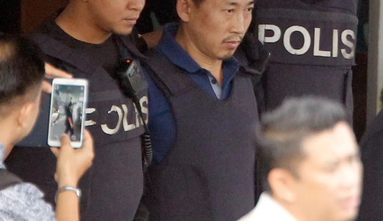 Anggota polisi mengawal WN Korea Utara, Ri Jong Chol (tengah) menuju kantor imigrasi Malaysia, di markas Polisi Sepang, Jumat (3/3). Ri Jong Chol, tersangka pembunuh Kim Jong-nam, akan dideportasi tanpa tuduhan apapun. (Muneyoshi Someya/Kyodo News via AP)
