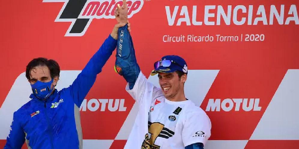 Pembalap Suzuki Ecstar, Joan Mir (kanan) merayakannya dengan Manajer Tim Davide Brivio setelah memenangkan kejuaraan dunia MotoGP setelah Grand Prix Valencia di sirkuit Ricardo Tormo di Valencia (15/11/2020). (AFP/Lluis Gen)