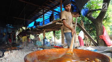Pekerja mengaduk adonan untuk membuat dodol Betawi di kawasan Studio Alam TVRI, Cilodong, Depok (31/5). Dodol ini menjadi salah satu kuliner khas Betawi yang sering dijumpai ketika Lebaran. (Merdeka.com/Arie Basuki)