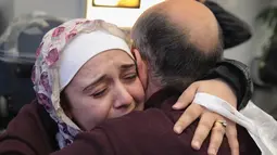 Pengungsi asal Suriah Baraa Haj Khalaf, dipeluk ayahnya saat tiba di bandara Internasional O'Hare, AS, Rabu (7/2). Baraa dan keluarganya harus menjalani introgasi panjang agar bisa melewati otoritas bandara. (AFP Photo/ Scott Olson)