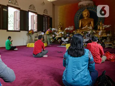 Sejumlah umat Buddha melakukan ibadah Hari Raya Tri Suci Waisak di Vihara Jakarta Dhammacakka Jaya, Rabu (26/5/2021). Pelaksanaan upacara Trisuci Waisak 2565/2021 dirayakan oleh umat Buddha secara terbatas dengan menerapkan protokol kesehatan secara ketat. (Liputan6.com/Faizal Fanani)