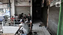 Sejumlah pedagang berkumpul di depan toko yang tutup di Pasar Rawamangun, Jakarta, Minggu (28/6/2020). Penutupan dilakukan setelah satu orang pedagang positif Covid-19 berdasarkan hasil tes usap atau swab beberapa waktu lalu. (merdeka.com/Iqbal S. Nugroho)