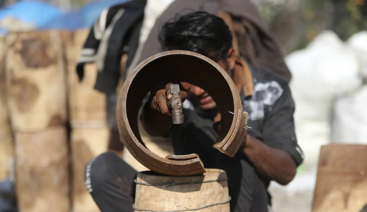 Seorang pria membuat genderang tradisional di daerah kumuh di Jammu, India (19/1/2021). Genderang tradisional ini digunakan terutama saat pernikahan dan prosesi keagamaan. (AP Photo / Channi Anand)