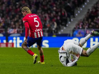Pemain  Real Madrid, Brahim Diaz, terjatuh saat berebut bola dengan pemain Atletico Madrid, Rodrigo De Paul, dalam laga babak 16 besar Copa del Rey 2023/2024 yang digelar di Metropolitano, Jumat (19/1/2024). Los Rojiblancos  menang dengan skor 4-2. (AP Photo/Manu Fernandez)