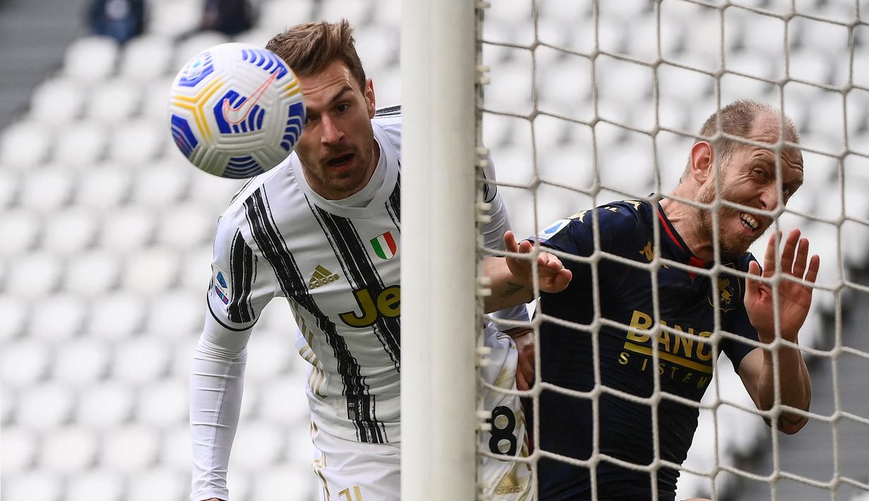 Gelandang Juventus, Aaron Ramsey (kiri) dibayangi bek Genoa, Andrea Masiello melepaskan sundulan ke gawang Genoa dalam laga lanjutan Liga Italia 2020/2021 pekan ke-30 di Allianz Stadium, Turin, Minggu (11/4/2021). Juventus menang 3-1 atas Genoa. (AFP/Marco Bertorello)