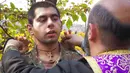 Pendeta Aristakes Hovhannisyan menempatkan salib pada seorang tentara etnis Armenia selama upacara pembaptisan di sebuah kamp militer dekat garis depan konflik di wilayah separatis Nagorno-Karabakh, Azerbaijan, Senin (2/11/2020). (AP Photo)