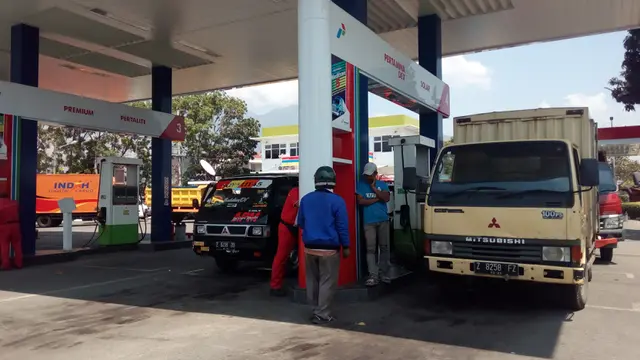 Beberapa petugas SPBU tengah sibuk melayani antrian pembelian bahan bakar solar oleh kendaraan angkutan di kabupaten Garut