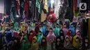 Seorang perempuan melintas di depan penjual gamis dan baju anak di pasar Parung, Bogor, Jawa Barat, Kamis (18/2/2021). Dampak pandemi COVID-19 yang berkepanjangan pedagang mengaku omset penjualan gamis dan baju anak turun 85 persen semenjak awal tahun lalu hingga sekarang. (Liputan6.com/Johan Tallo)