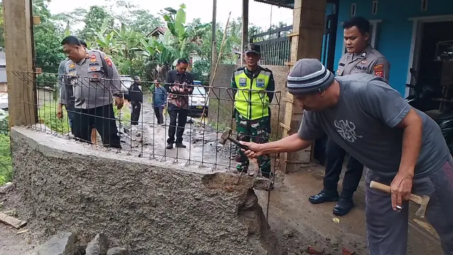 Proses pembongkaran tembok yang menutup akses jalan di desa Mandalasi, Tasikmalaya oleh aparat gabungan TNU-Polri, petugas Kecamatan Puspahiang, dan petugas dan BPD Desa Mandalasari. (Liputan6.com/Jayadi Supriadin)