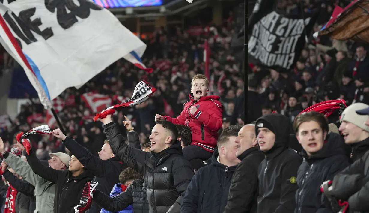 Suporter PSV memberikan dukungan kepada timnya saat laga leg 2 babak play off Liga Champions 2024/2025 melawan Juventus di Philips Stadion, Eindhoven, Belanda, Rabu (19/02/2025) waktu setempat. (AP Photo/Peter Dejong)