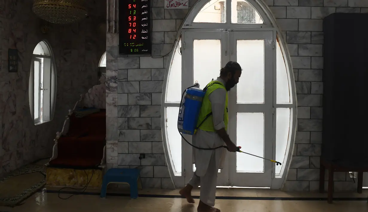 Seorang pekerja menyemprotkan disinfektan di masjid menjelang Ramadan selama penguncian nasional yang diberlakukan pemerintah sebagai tindakan pencegahan terhadap coronavirus COVID-19, di Karachi, Pakistan (21/4/2020). (AFP/Asif Hassan)