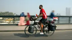 Seorang pria Mesir, Mohammed Nufal (24) mengendarai sepedanya melintasi jembatan Qasr El-Nile di Kairo, Sabtu (7/4). Nufal mengayuh sepedanya sejauh 5000 kilometer menuju Rusia, demi mendukung timnas Mesir di Piala Dunia 2018. (AP/Amr Nabil)