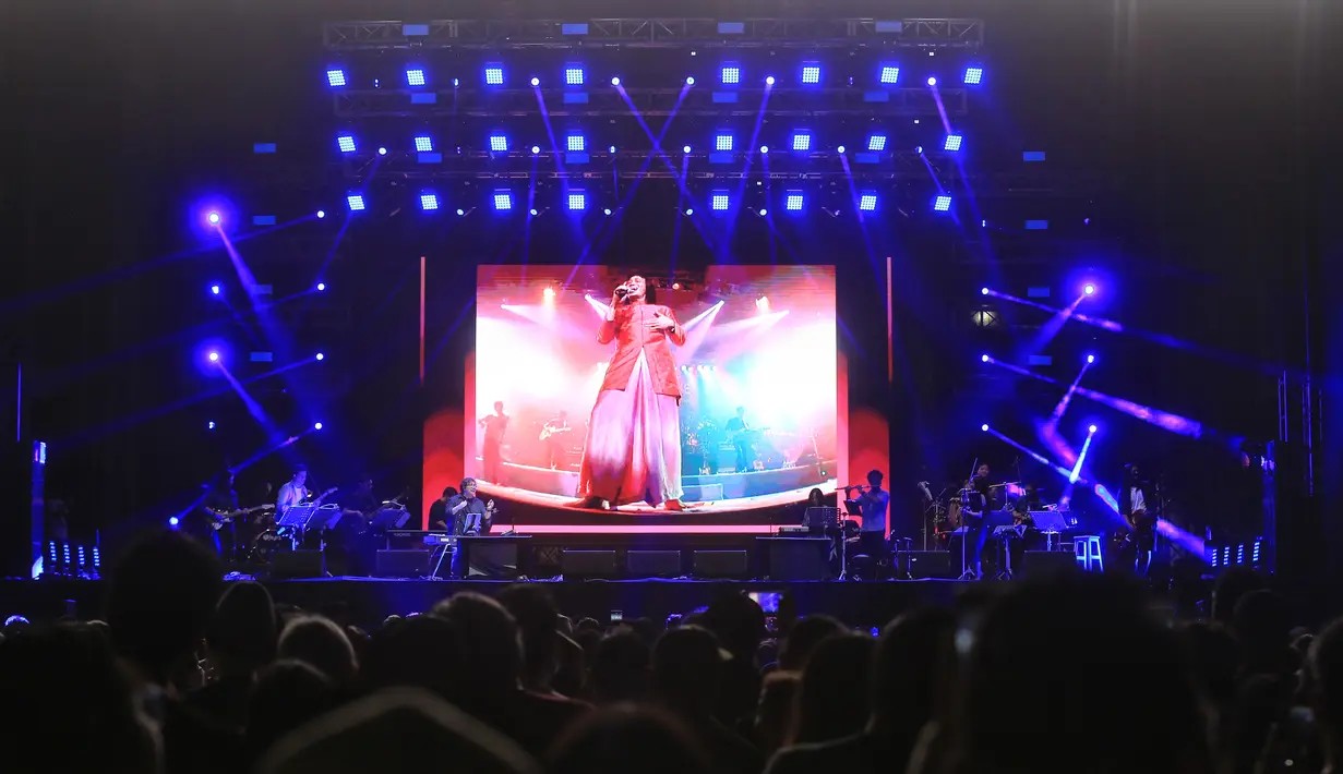 Nuansa lain disuguhkan Erwin Gutawa dalam set Chrisye Live. Sang legenda kembali hadir dalam layar, bernyanyi memandu penonton. [Adrian Putra/Fimela.com]