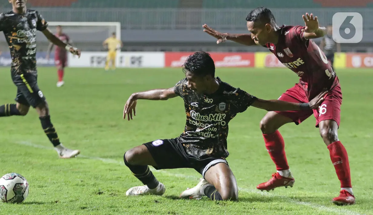 Pemain depan Persis Solo, M Abduh Lestaluhu (kanan) berebut bola dengan pemain Rans Cilegon United pada laga Final Liga 2 Indonesia 2021 di Stadion Pakansari, Bogor, Kamis (30/12/2021). Persis Solo unggul 2-1. (Liputan6.com/Helmi Fithriansyah)