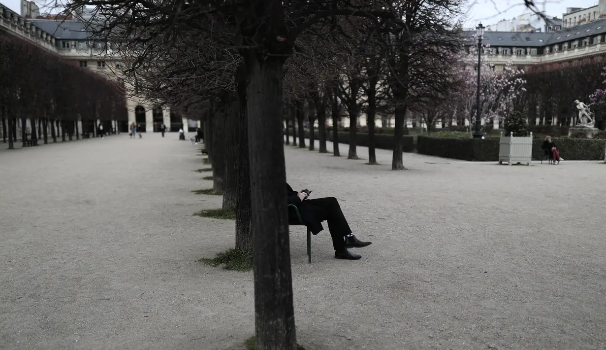 Seorang pria duduk di taman Royal Palais di Paris (22/3/2021).Sementara pemerintah Prancis bersikeras bahwa aturan tersebut tidak akan seketat di masa lalu, tindakan tersebut dikritik karena dianggap berantakan. (AP Photo/Lewis Joly)