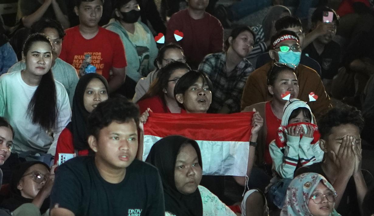 Wajah tegang para suporter Indonesia saat acara nonton bareng laga perebutan tempat ketiga Piala Asia U-23 2024 antara Timnas Indonesia U-23 menghadapi Irak di Plaza Kemenpora, Senayan, Jakarta Pusat, Kamis (2/5/2024) malam WIB. (Bola.com/Afi)