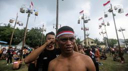 Seorang peserta mengikuti lomba panjat pohon pinang di Pantai Festival Ancol, Jakarta, Rabu (17/8/2022). Sebanyak 45 pohon pinang siap dipanjat oleh pengunjung di Pantai Festival Ancol  untuk memeriahkan Hari Ulang Tahun (HUT) Ke-77 Republik Indonesia. (Liputan6.com/Faizal Fanani)