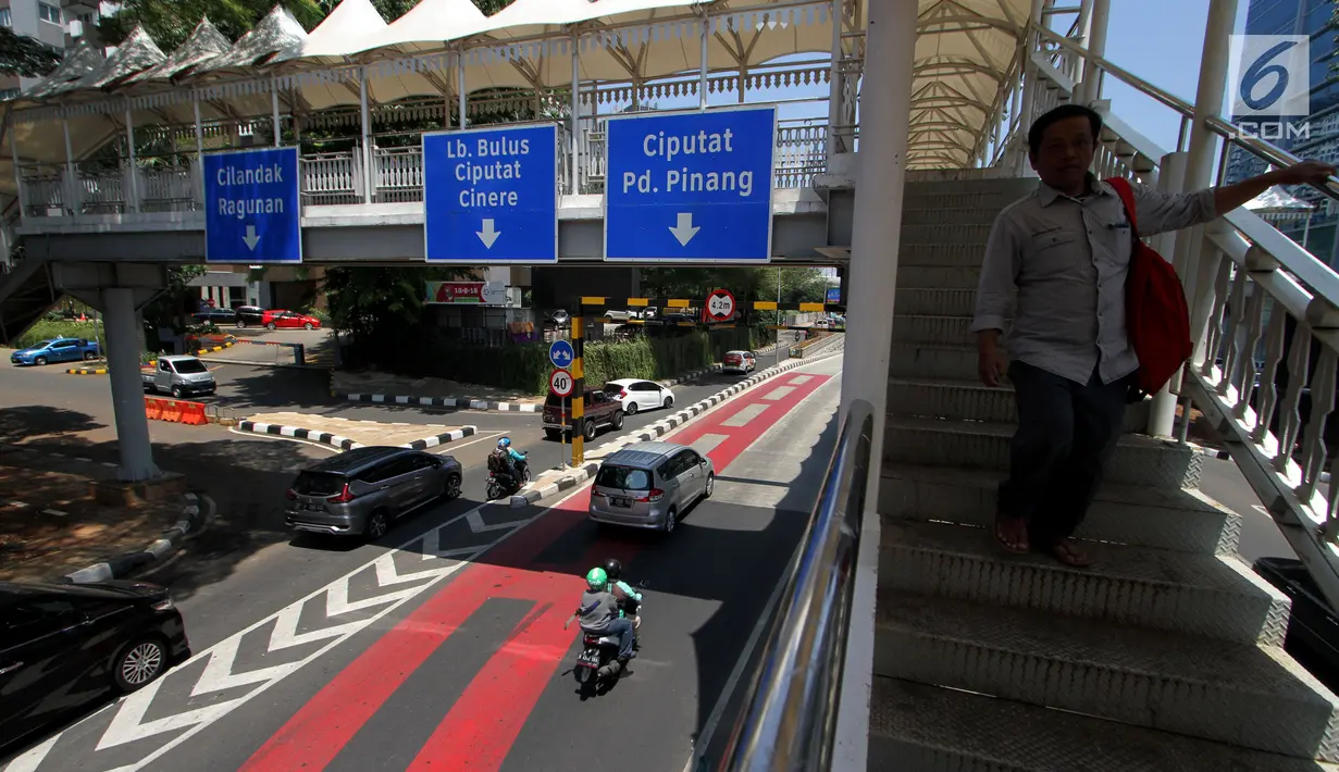 Seorang pria berjalan di JPO di kawasan Jalan Metro Pondok Indah, Jakarta, Senin (3/9). Penerapan sistem ganjil-genap di Jalan Metro Pondok Indah dihapus karena tidak ada kegiatan Asian Para Games di kawasan tersebut. (Liputan6.com/Johan Tallo)