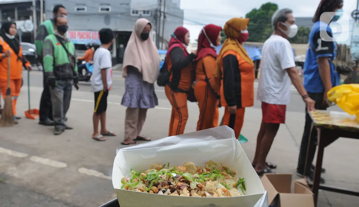 Warga mengantre untuk mendapatkan bubur gratis di kawasan  pintu keluar tol Kukusan Depok, Jawa Barat, Kamis (20/1/20222). Sumber dananya berasal dari dana pribadi seorang pengusaha warteg dan donasi dari berbagai elemen masyarakat sebagai wujud kepedulian kepada sesama. (merdeka.com/Arie Basuki)